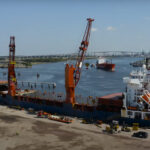 Featured image showing the UTC Overseas logistics crew use a heavy-lift vessel at Port of Houston to load cranes for transport.