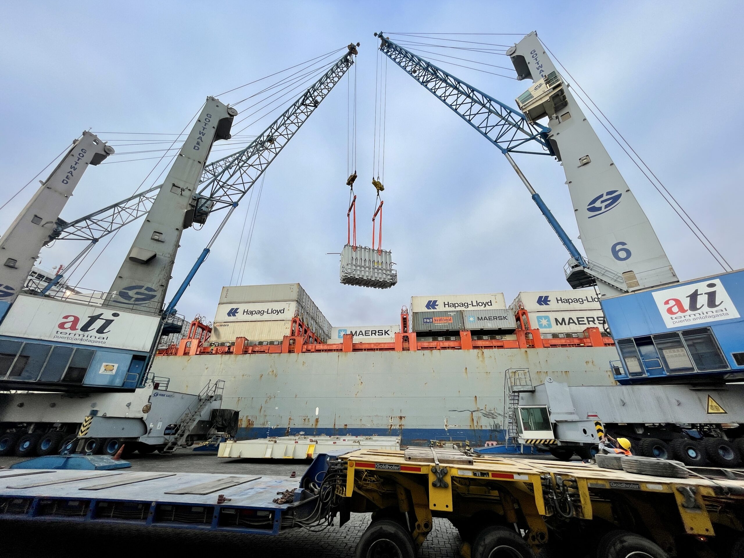 Featured image showing the UTC Overseas transport team using cranes to lift a transformer.