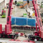 cranes lifting genset at final jobsite onto SPMTs, multimodal delivery