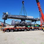 rail-mounted gantry crane parts being positioned on trailer