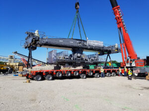 rail-mounted gantry crane parts being positioned on trailer