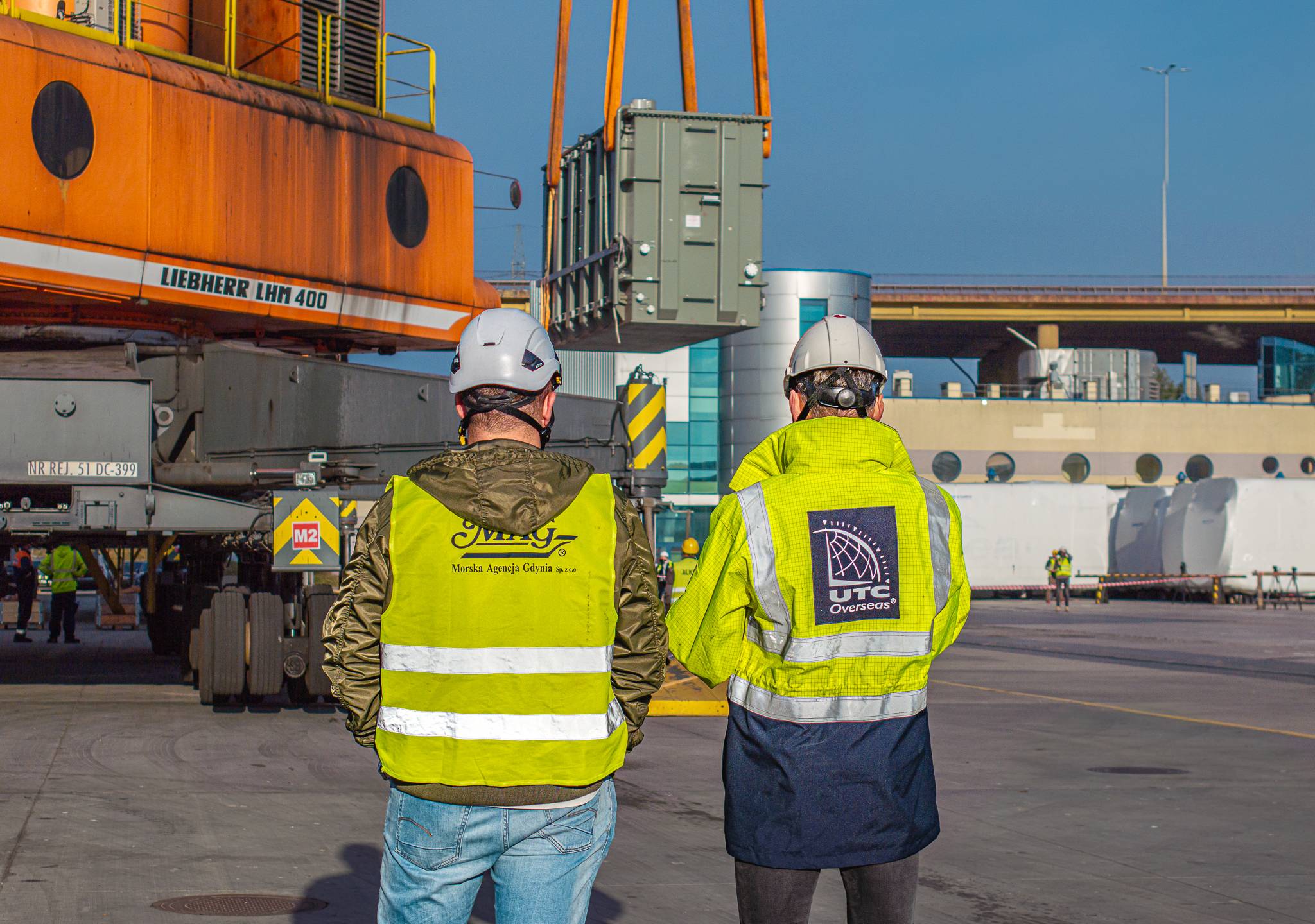 Featured image showing two UTC Overseas Logistics experts transporting oversized electrical equipment.