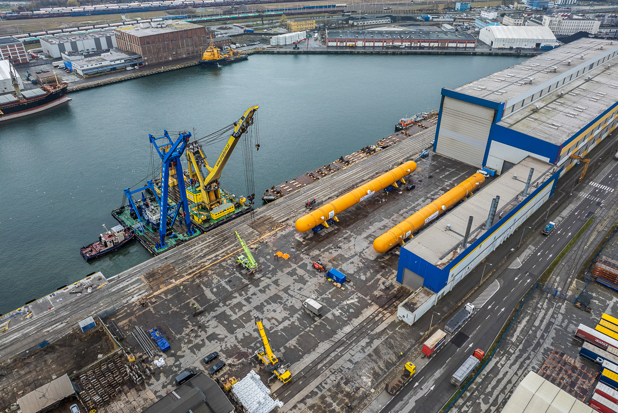 Heavy lift staging area with oversized LPG tanks and transport equipment at Polish port facility