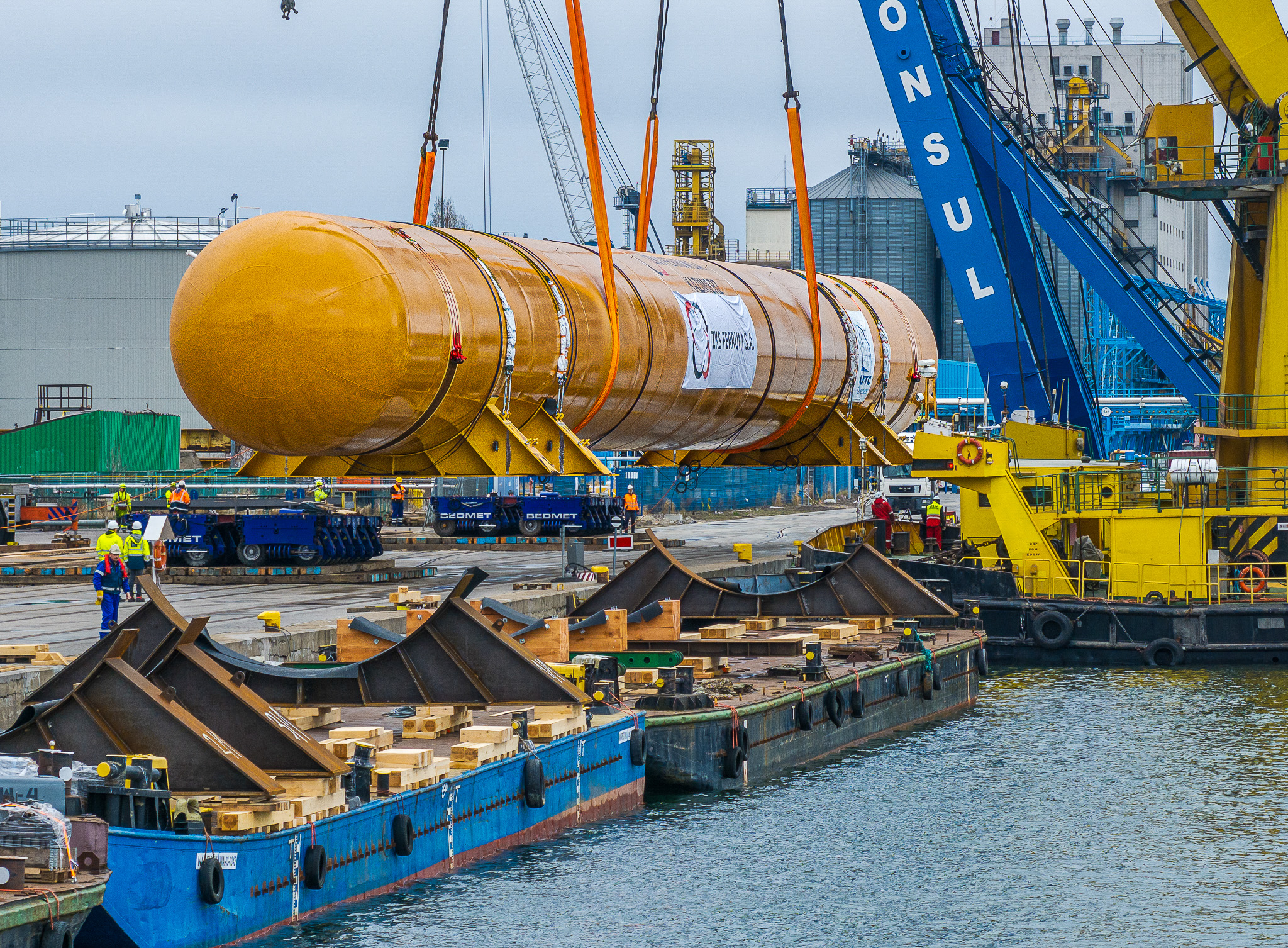 Heavy lift crane loading 465-ton LPG storage tank onto barge at Gdynia fabrication facility in Poland